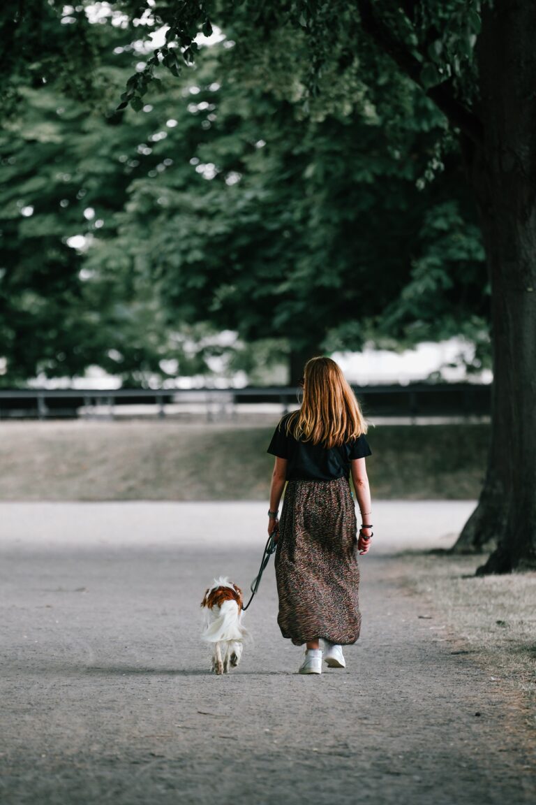 Une femme qui promène son chien en laisse